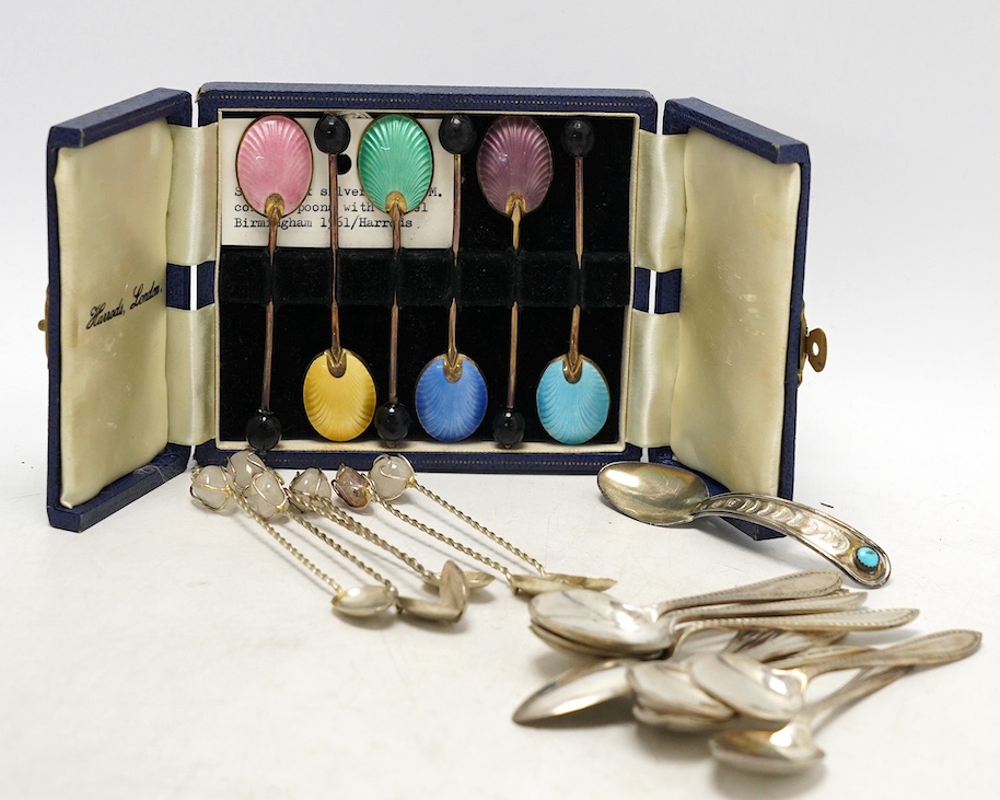A set of ten George V silver coffee spoons, Birmingham, 1931, a later cased set of six silver and polychrome enamel bean end coffee spoons, a turquoise set sterling spoon, and a set of six white metal spoons with hardsto